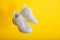 Levitation white sport shoes footwear on yellow wall. White sneakers shoes fly on yellow color background with copy