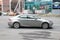 Lexus IS 300h Petrol hybrid on the street in motion. Silver sedan rushes in city road, side view