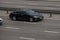 Lexus black speeding on empty highway