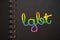 LGBT abbreviation in rainbow colors on black spiral copybook. LGBT equal rights concept