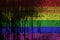 LGBT community flag depicted in paint colors on old and dirty oil barrel wall closeup. Textured banner on rough background