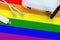 LGBT community flag depicted on table with internet rj45 cable, wireless usb wifi adapter and router. Internet connection concept