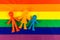 LGBT pride rights flag with family figurines. Gay and lesbian homosexual love background