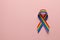 LGBT rainbow ribbon pride tape symbol. Stop homophobia. Pink background. Copy space for text.