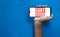 LGBT society Word on smart phone screen isolated on blue background with copy space for text. Person holding mobile on his hand