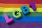 LGBT text inscription acronym word rainbow background over lgbtq flag
