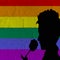 LGBT valentines day concept, a silhouette holding and smelling a rose, on a brick wall with rainbow flag pattern