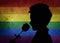LGBT valentines day concept, a silhouette holding and smelling a rose, on a stone wall with a rainbow flag pattern