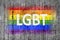 LGBT word and LGBT flag painted on background texture gray concrete