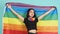 LGBTQ girl and pride flag. Sexy Lesbian girl and LGBT flag standing. blue green background. Asian LGBTQ woman with rainbow scarf o