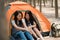 Lgbtq lesbian women couple camping or picnic together in forest, teenager female enjoy moment talking in front of their tent.