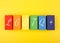 Lgbtq plus letters on rectangular geometric figures on yellow background.