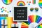 LGBTQ pride month text on letter board. Black letterboard with rainbow pattern objects on off white background. Party