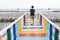 LGBTQ walking alone on colorful rainbow wooden bridge extends into the mangrove sea tourist attractions in Thailand.Lonely travel