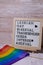 LGBTQIA description frame on Rainbow LGBTQIA flag made from silk material. LESBIAN, GAY, BISEXUAL, TRANSGENDER, QUEER