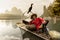 Li River - Xingping, China. Circa January 2016 - A fisherman resting with his cormorant on a bamboo raft.