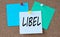 LIBEL - word on colorful pieces of paper attached to the note board