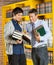 Librarian Holding Books While Explaining Student