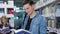 Library. Smiling male student reading book near shelves