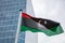 Libya flag on a pole waving, modern office building background