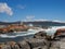 Lichen red rocks and inlet at Binalong Bay harbour Tasmania Australia