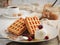 Liege waffles with caramel, berries and ice cream. Homemade waffles with delicious caramel sauce on a plate. Selective focus,