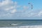 Liepaja, Latvia - September 29, 2019: Kiteboarder kitesurfer athlete performing kitesurfing in sea. Blue, cloudy sky