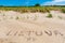 Lietuva word written with stones on the shore, sandy beach