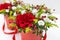 Life-affirming composition of fresh flowers Rose, Eustoma, Solidaga, Pistachio leaves and decorative berries in a scarlet cardbo