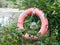 Life buoy safety ring orange red edge of lake for drowning