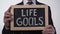 Life goals written on blackboard in businessman hands, success tips, motivation