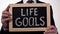 Life goals written on blackboard in businessman hands, success tips, motivation