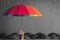 Life-health Insurance protection or business financial leadership concept with leader`s hand holding rainbow umbrella on black