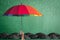 Life-health Insurance protection or business financial leadership concept with leader`s hand holding rainbow umbrella on green