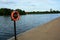 Life saving buoyancy ring at boating lake. Warning sign