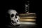 Life is short concept. Skull and vintage hourglass on old books and wooden table
