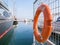 A lifebelt, lifebuoy, water wheely also known as Kisbee ring hanging from a fence at the harbour