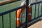 A lifebuoy is attached to a yacht or cruise ship, a lifebuoy on deck is tied to the railing of the boat. Turquoise sea background