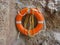 Lifebuoy from foam plastic hanging on the stone wall.