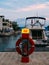 Lifebuoy in the marina for yachts. Red circle on the boat dock.