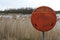 Lifebuoy beside open water and reeds