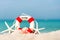 Lifebuoy on sand beach background with starfish and fishing boat, copy space.