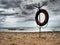 Lifebuoy on a sandy beach. Orange lifebuoy on a pole to rescue people drowning in the sea. Rescue point on the shore