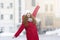 Lifeful young woman posing over winter city background