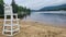 Lifegaurd chair and swimming area atAdirondack Lake Beach upstate New York raid clouds and mountain forest lake