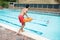 Lifeguard jumping into a swimming pool to rescue drowning boy