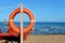 Lifeguard lifebuoy by the sea. People Rescue Equipment. Service for rescue. Tree with orange life jacket on the beach by the sea