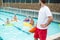 Lifeguard looking at swimmers swimming in pool