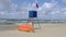 Lifeguard post with a ref flag on it informing about the danger of the wind in the sea