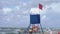 Lifeguard post with a ref flag on it informing about the danger of the wind in the sea